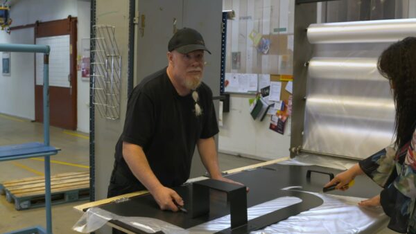 Två medarbetare skär ut plast efter en mall