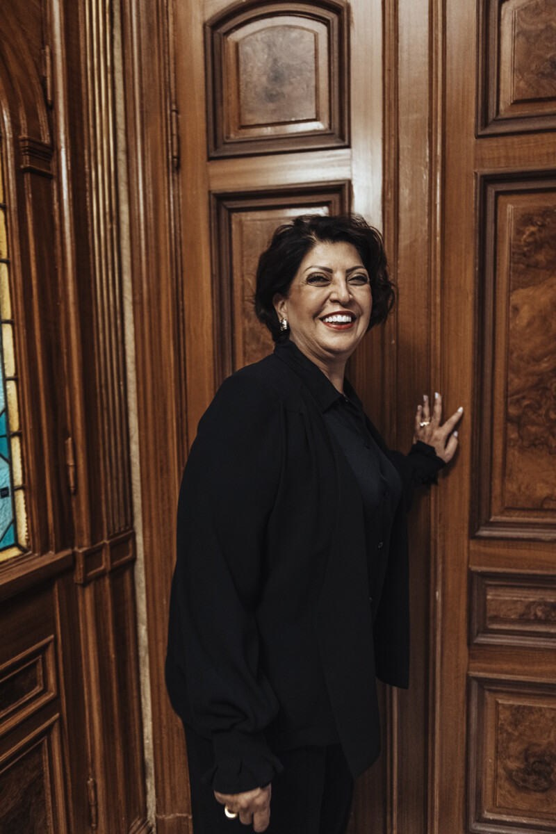 Kvinna med kort mörkt hår är på väg in igenom en gammal trädörr