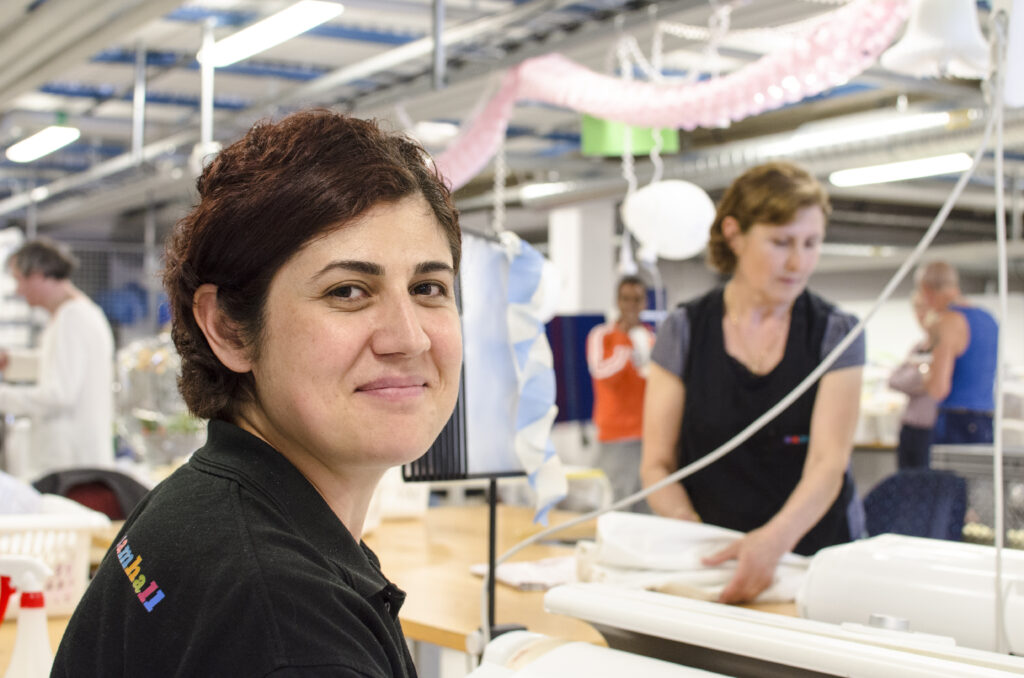 Personer jobbar. En kvinna tittar in kameran