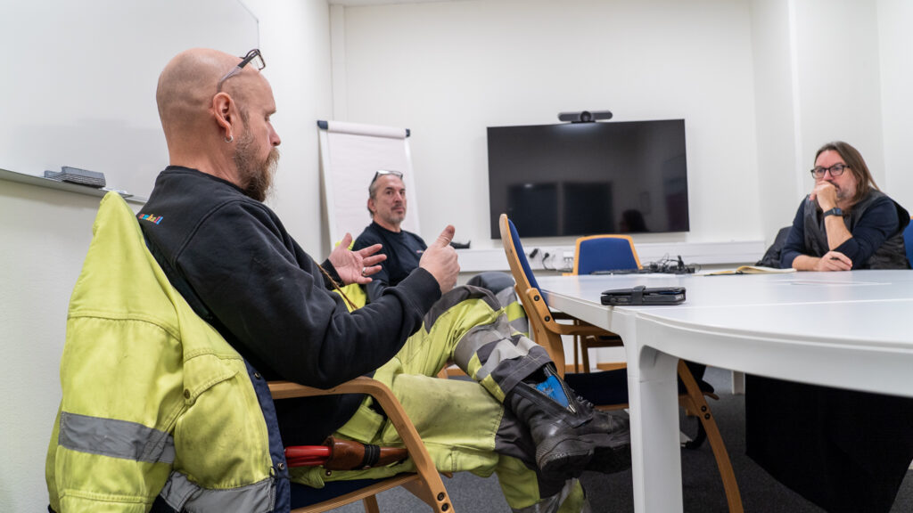 Personer i arbetskläder runt bord