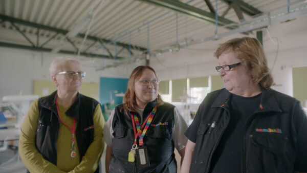 Tre personer med samhall-kläder