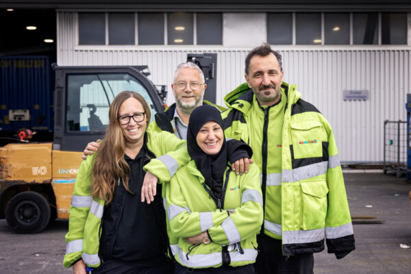Medarbetarbild på fyra personer bärandes reflexjackor. Alla tittar in i kameran och ler. 