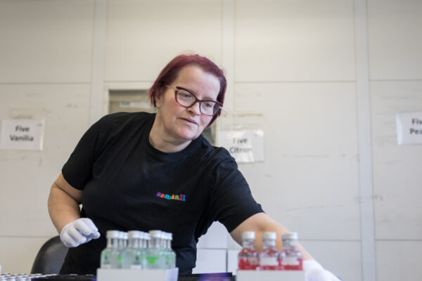 Eva Christoffersson sorterar varor. Hon bär svart klädsel. 