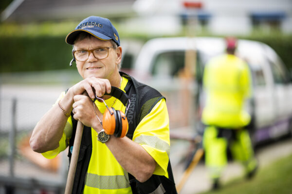 Mats Fundin står lutad mot en kratta och ser in i kameran. Han bär en blå keps.