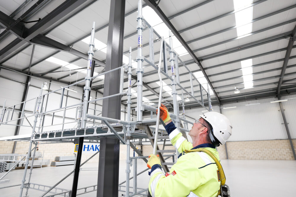 Person med arbetskläder bygger en ställning