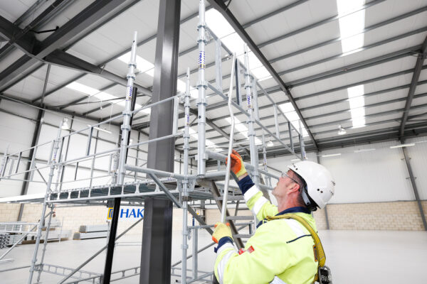 Person med arbetskläder bygger en ställning