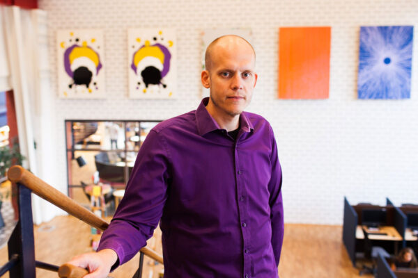 Man med rakat hår och lila skjorta i en trappa i en kontorsmiljö