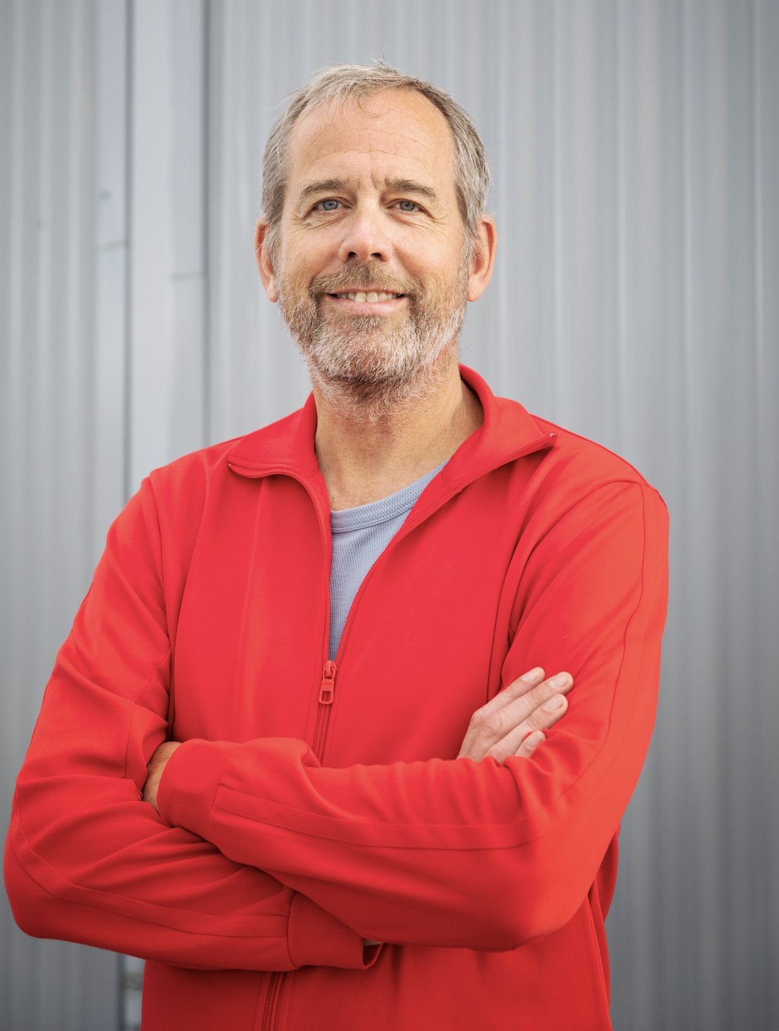 Porträtt av Jörgen Lorentzon. Står mot en vit bakgrund och bär en röd tröja.