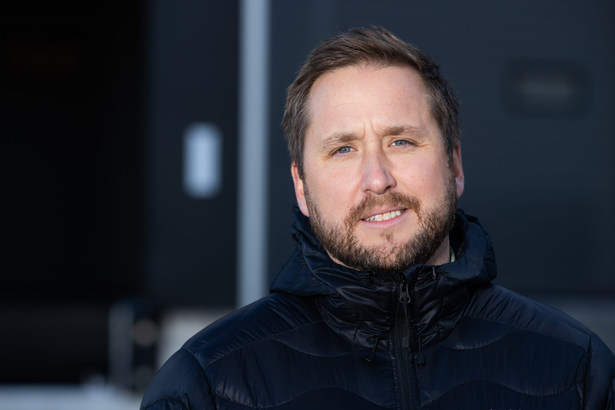 Man i svart jacka tittar in i kameran.