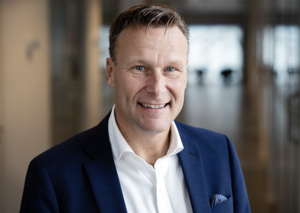 Porträtt av Henric Ungh, vd på Beneli, som led och tittar in i kameran. han bär en mörkblå kavaj och vit skjorta. 