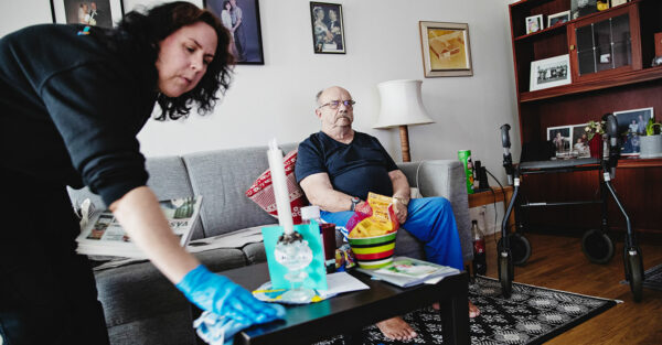 Monika Nilsson torkar med en trasa på vardagsrumsbordet hemma hos Mikael Taskinen.