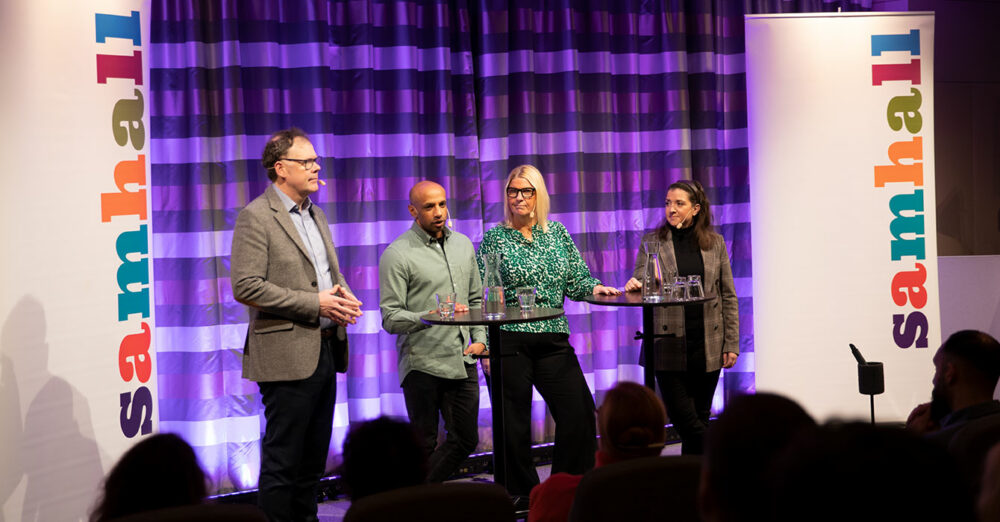 En bild på seminariescenen där Christian Horne , Aaron Kroon, Charlotte Zetterlund och Ann Mårder står på rad. Bakom dem står det två Samhall-skyltar.